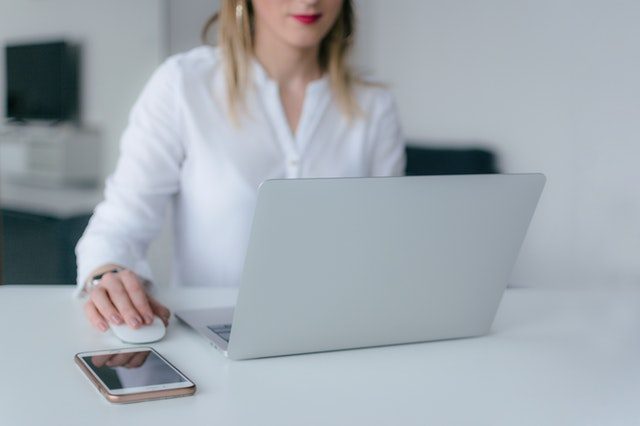 A laptop and notebook on a desk